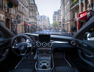 A car is parked in a city street with a view of the dashboard