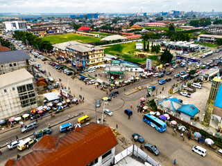 Port Harcourt, Nigeria - 15 November 2024: Aerial view of Aggrey Road's bustling intersection, where vehicles navigate past vibrant buildings under a vast sky.