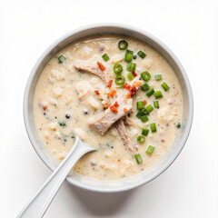 Creamy Chicken Soup Delight: A top-down view presents a delectable bowl of creamy chicken soup, garnished with fresh green onions, savory bacon bits, and a clean white spoon.