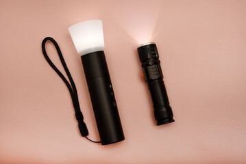 A flashlight for studio lighting. Compact flashlight for the photographer. A flashlight on a pink background.