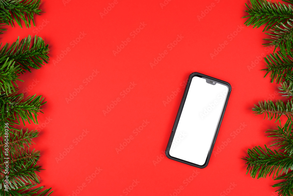Poster red christmas copy space background with fir tree twig frame and mobile phone with blank display iso