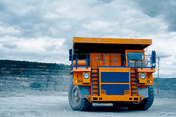 Orange mining truck against background of the slopes of an asbestos quarry