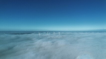 Aerial View of Wind Turbines Emerging from Clouds