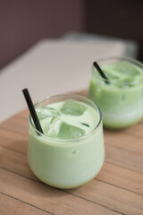 Iced matcha latte, creamy and refreshing beverage,  on the garden table in summer.