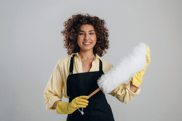 Housewife is ready to clean the house. Beautiful woman is in the studio