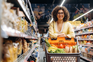 Just standing and smiling. Gorgeous woman is in the grocery store