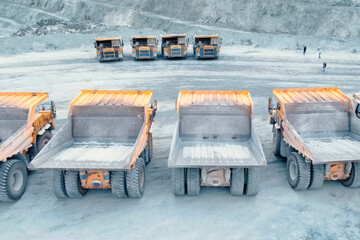 Mining dump trucks are parked in row. Equipment for an industria