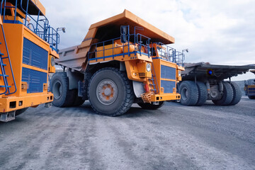 Mining dump trucks are parked in row. Equipment for an industrial quarry.