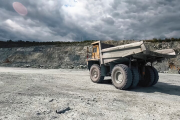 larger mining dump truck in the quarry against the background of