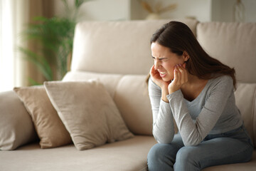 Woman suffering tmj syndrome complaining alone at home