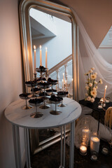 Wedding reception decoration showcases berries stand with candles and flowers, creating a romantic...