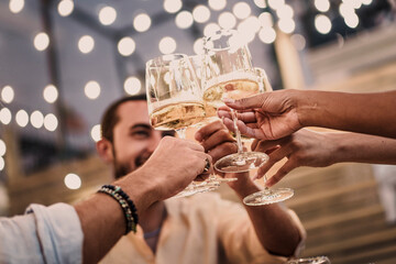 Friends toasting with champagne glasses at a celebration party with festive bokeh lights.