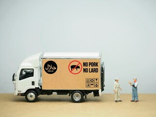 Mini toy of action figure and truck car at table with blurred background. Toy photography concept....