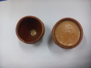 This photo shows a traditional kulhad (clay cup) filled with chai (Indian tea).These clay cups are commonly used to serve hot tea in India, especially at roadside tea shops. Kulhad chai has a distinc