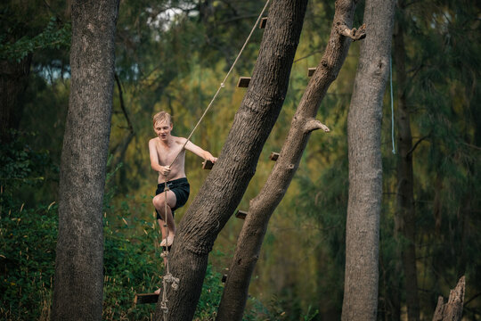 Teenage boy using rope swing at the river