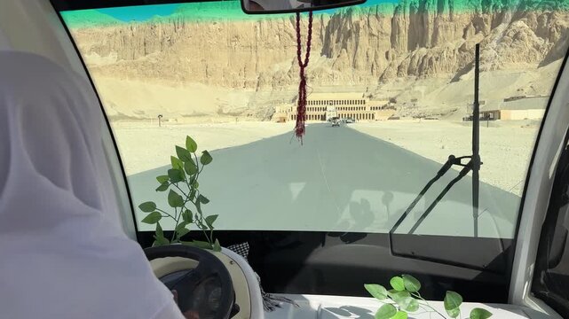 Driver approaching hatshepsut temple in electric vehicle