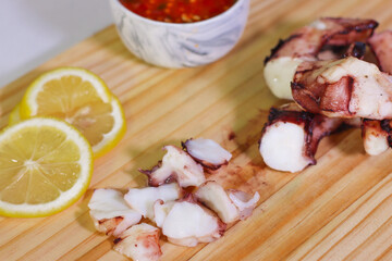 Grilled octopus slices with dipping sauce and lemon