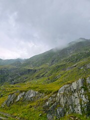 Naklejka premium Fagaras Mountain top in the fog seen from the Transfagarasan road on a cloudy summer day. Sibiu, Cluj