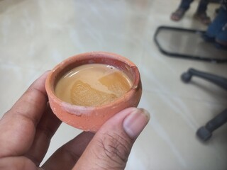 This photo shows a traditional kulhad (clay cup) filled with chai (Indian tea).These clay cups are commonly used to serve hot tea in India, especially at roadside tea shops. Kulhad chai has a distinc