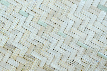A detailed, close-up shot of a woven bamboo mat, showcasing its natural texture and intricate herringbone pattern.