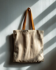 Canvas tote bag hanging on a wall with soft shadows creating an artistic effect during the afternoon light