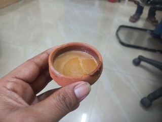 This photo shows a traditional kulhad (clay cup) filled with chai (Indian tea).These clay cups are...