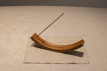 Smoking incense stick on a beige background.