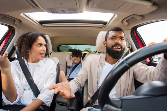 Latin parents arguing while driving car, kid boy feeling sad upset and covering ears with hands while mom and dad having conflict during car trip - Powered by Adobe