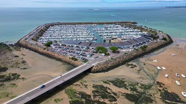 The iconic Port de Plaisance marina enclosed in circular stone wall near sandy beach of Pornichet, Loire-Atlantique, France. Low tide