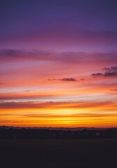 Naklejka premium Vibrant Sunset Landscape with Orange and Purple Hues