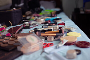 Fototapeta premium A variety of makeup products and beauty tools scattered across a bed