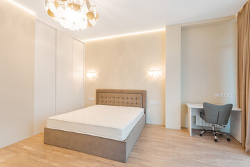 Modern bedroom with minimalist design featuring a bed and workspace in a softly lit setting