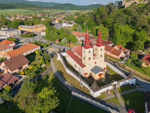 Aerial view of the Church of All Saints standing proudly with its red-roofed towers against the backdrop of lush greenery, Div&Atilde;&shy;n, Bansk&Atilde;&iexcl; Bystrica Region, Slovakia.