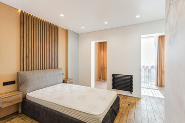 Modern bedroom design featuring natural wood accents and large windows in a contemporary home