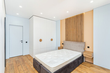 Modern bedroom interior featuring minimalist design and wooden accents in a bright, spacious setting
