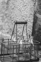 Fototapeta premium an old tray with old empty milk bottles in black and white