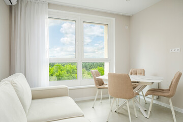 Bright and airy dining area with a view of green trees in a contemporary apartment