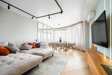 Spacious modern living room with large windows and stylish furniture in a contemporary apartment