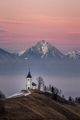 Church of St Primoz on Hilltop with Snowy Julian Alps at Sunrise in Slovenia