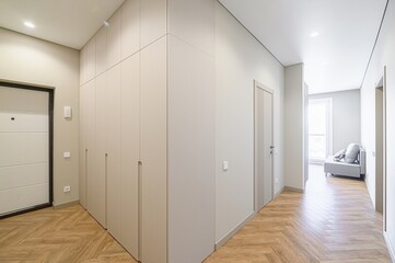 Clean, modern hallway. Neutral palette, built-in wardrobes, herringbone wood floor. Minimalist design