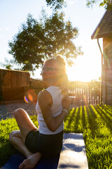 woman doing yoga at sunset outdoors