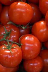 Fresh ripe red tomatoes closely stacked together in a produce display