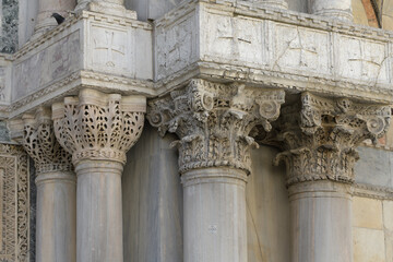 Detail of ornate capitals on marble columns at the facade of San Marco Basilica, Venice, Italy.