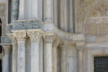 Detail of ornate capitals on marble columns at the facade of San Marco Basilica, Venice, Italy.