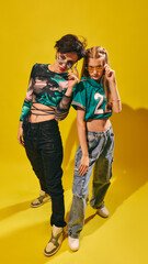 Two stylish youth posing in bold streetwear and sunglasses on vibrant yellow background. Concept of youth fashion, streetwear culture, pop culture editorials, and event promo.