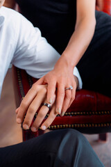 Fototapeta premium Close-Up of Couple's Hands with Engagement and Wedding Rings