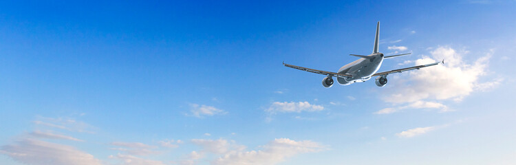 Passenger airplane flying in blue sky with few clouds