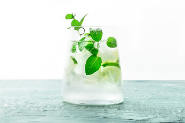 Lime lemonade, or limeade, in a glass with lime, mint, and plenty of ice. Fresh summer Mojito mocktail or cocktail