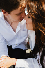 Young married couple enjoys a tender moment, with sunlight highlighting their joyful expressions...