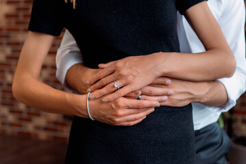 Romantic embrace with engagement ring and couple’s hands